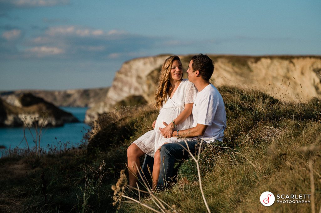 Couple with maternity dress sitting at north island newquay