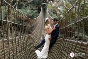 Elopement couple take a moment on the rope bridge at Heligan Gardens