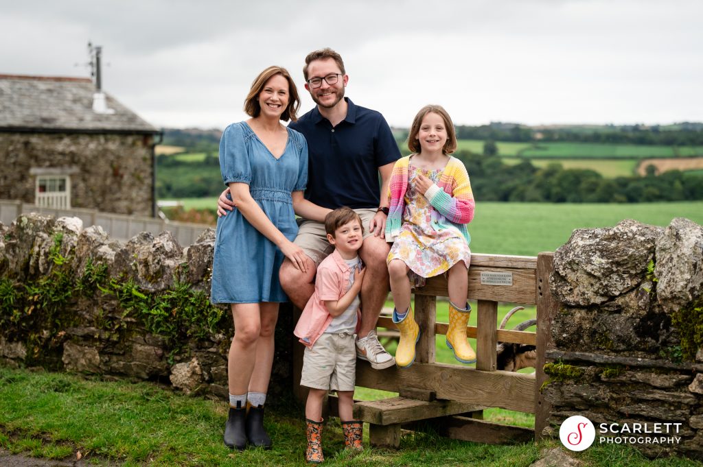 A family of four pose for a family photoshoot in cornwall