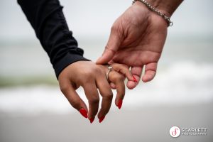 Close up of a couples hands touching showing off their engagement ring