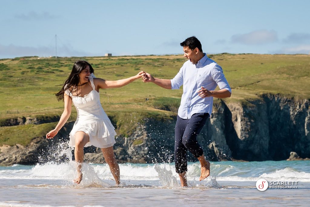 a man and woman running in the water