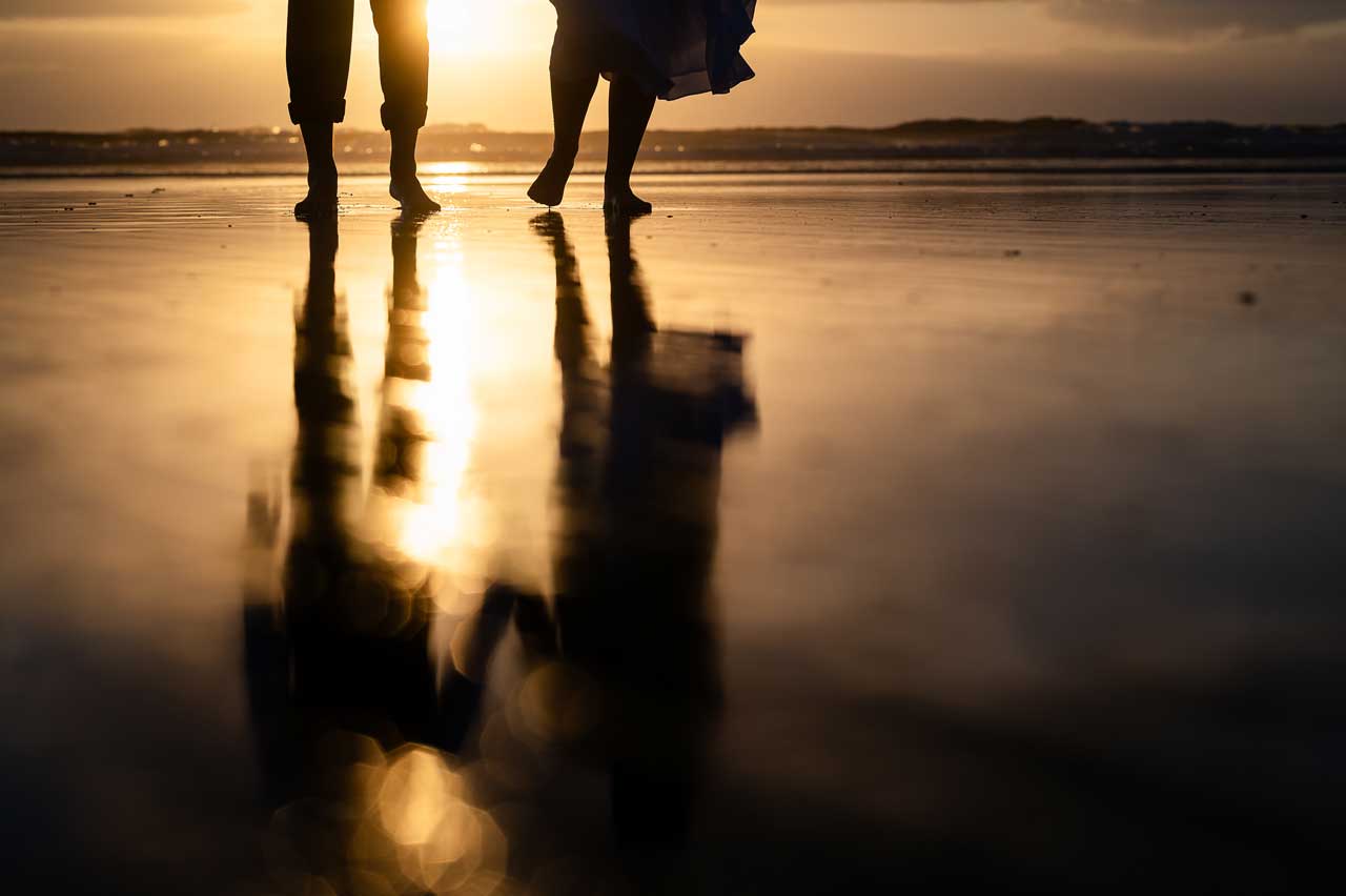 Bride and groom at sunset on Fistral Beach, Cornwall wedding photography